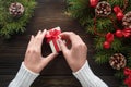 Beautiful female hands holding a Christmas present in box with red bow. Royalty Free Stock Photo