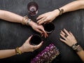 Beautiful female hands with jewelry at the table with glasses of