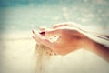Beautiful female hands and the sand on the sea background Royalty Free Stock Photo
