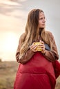 Beautiful female holding cup of tea in hands standing in contemplation of nature