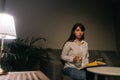 Beautiful female is holding a glass of water in hand in a dark room. Royalty Free Stock Photo