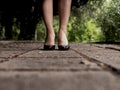 Beautiful female legs in black patent-leather shoes on outdoor tiles Royalty Free Stock Photo