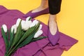 Beautiful female legs are dressed in stylish violet flat shoes. violet sandals on a yellow background Royalty Free Stock Photo