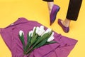 Beautiful female legs are dressed in stylish violet flat shoes. violet sandals on a yellow background Royalty Free Stock Photo