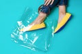 Beautiful female legs are dressed in stylish yellow shoes without a heel. Light yellow summer sandals on a blue background and a Royalty Free Stock Photo