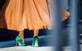 Beautiful female legs in high heel shoes. close-up. green suede pumps. Girl dancing and spinning in a magnificent dress.