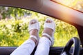Female legs in boots and jeans hanging out of the car window Royalty Free Stock Photo