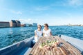 A beautiful female lesbian couple in white dresses on a boat, a Royalty Free Stock Photo