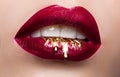 Beautiful female lips closeup. Red lipstick, gold paint flowing over his lips. Stock Photo