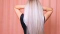 Beautiful female luxurious long straight blond hair. Dyed wavy white blond hair background, dyeing, extensions