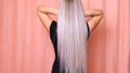 Beautiful female luxurious long straight blond hair. Dyed wavy white blond hair background, dyeing, extensions