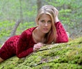 Beautiful female model posing on moss covered log Royalty Free Stock Photo