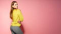 Beautiful female model wears casual comfrotable sweater, poses against pink background. Copyspace Royalty Free Stock Photo