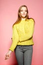 Beautiful female model wears casual comfrotable sweater, poses against pink background. Copyspace Royalty Free Stock Photo