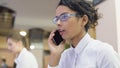 Beautiful female office worker in eyeglasses talking on phone, personal call