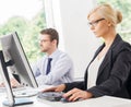 Beautiful female office worker in formalwear with colleague on background