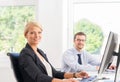 Beautiful female office worker in formalwear with colleague on background Royalty Free Stock Photo