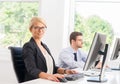 Beautiful female office worker in formalwear with colleague on background Royalty Free Stock Photo