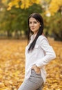 Beautiful female office worker walks in autumn park during lunch time. Relaxation, enjoying, solitude with nature. Stress relief Royalty Free Stock Photo