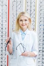 beautiful female ophthalmologist holding glasses and standing Royalty Free Stock Photo