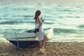 Beautiful female in the pareo near boat on the sand Royalty Free Stock Photo