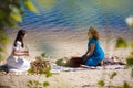 Beautiful female receiving energy sound massage with singing bowls and body massage on a river bank Royalty Free Stock Photo