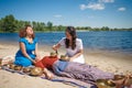 Beautiful female receiving energy sound massage with singing bowls and body massage on a river bank Royalty Free Stock Photo