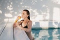 Beautiful female relaxing in summer swim pool and drinking refreshing cocktail. Royalty Free Stock Photo