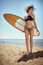 Beautiful female shaking off water from hair, holding surfboard Royalty Free Stock Photo