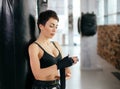 Beautiful female with short black hair putting on straps while work out