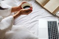 Beautiful female sitting on the bed and reading a book