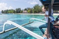 Beautiful female solo traveler relaxing and enjoying beautiful blue sea on traditional wooden boat after scuba diving Royalty Free Stock Photo