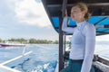 Beautiful female solo traveler relaxing and enjoying beautiful blue sea on traditional wooden boat after scuba diving Royalty Free Stock Photo