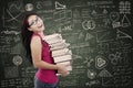 Beautiful female student bring stack of books in class Royalty Free Stock Photo