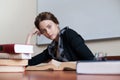 Beautiful female student at a table with books