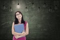 Beautiful female student under light bulbs in class Royalty Free Stock Photo