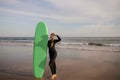 Beautiful Female Surfer Standing On The Beach And Holding Surf Board Royalty Free Stock Photo
