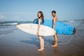beautiful female surfers and men with surfboards stand waiting for waves Royalty Free Stock Photo