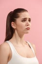 The young woman is looking sad on the pink background. Royalty Free Stock Photo