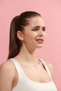 The young woman is looking sad on the pink background. Royalty Free Stock Photo