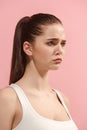 The young woman is looking sad on the pink background. Royalty Free Stock Photo