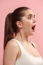 The young woman is looking surprising on the pink background. Royalty Free Stock Photo