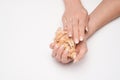 Beautiful Female well-groomed Hands with French manicure holding sea shell over light background Royalty Free Stock Photo