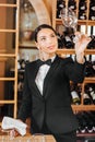 beautiful female wine steward checking clear glass