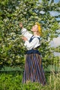 Beautiful feminime woman in national dress with white spring flowers