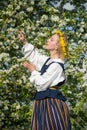 Beautiful feminime woman in national dress with white spring flowers