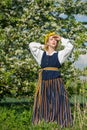 Beautiful feminime woman in national dress with white spring flowers