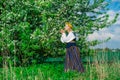 Beautiful feminime woman in national dress with white spring flowers