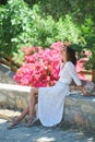 Beautiful femininity young woman sitting at garden with flowers. Spring time and woman& x27;s day Royalty Free Stock Photo