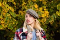 Beautiful femme wearing plaid scarf and cap in parisian style. Autumnal fashion concept. Beautiful romantic blonde girl